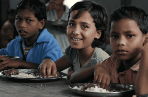 Una bambina in India che mangia un pasto caldo