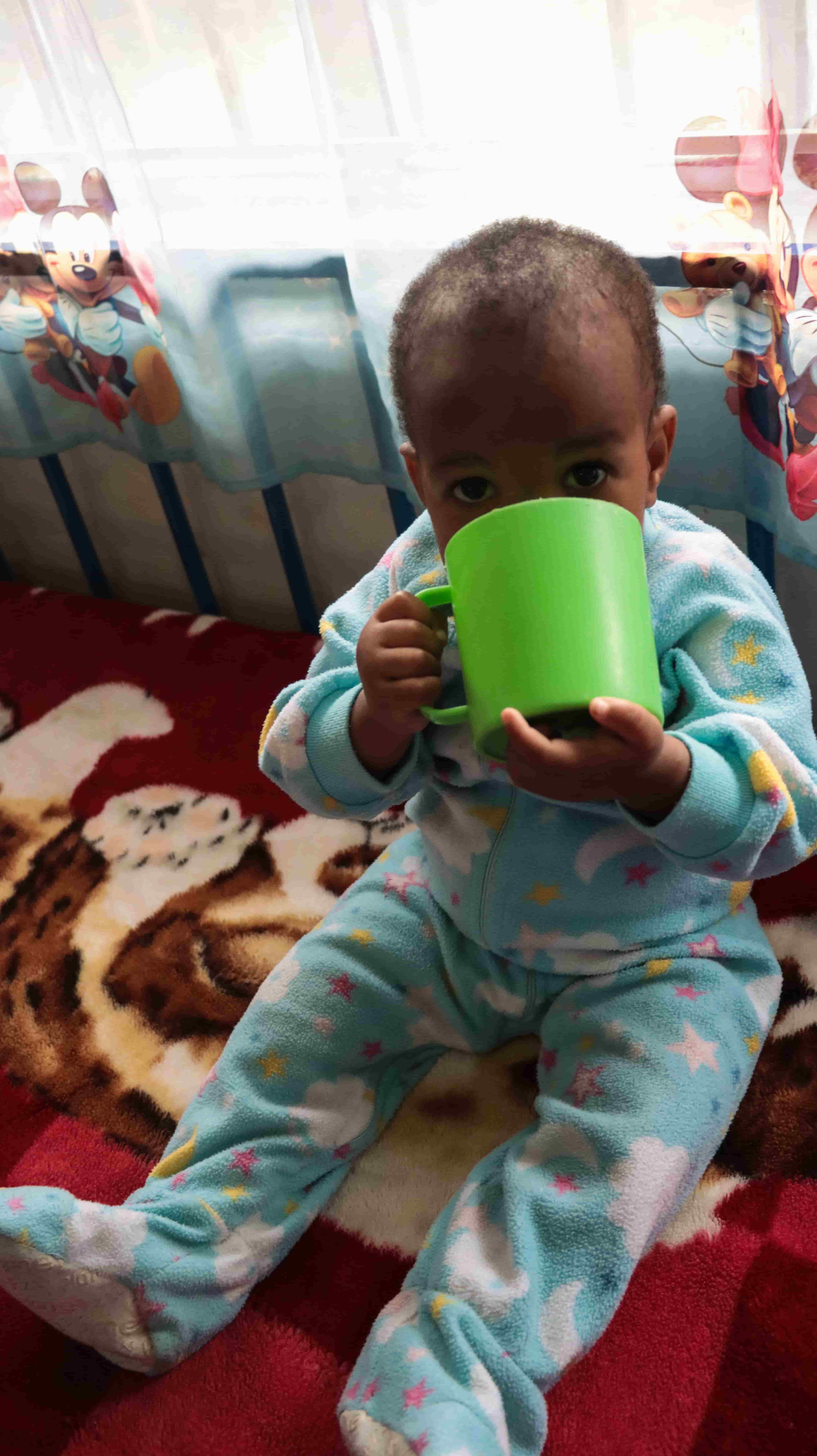 Kenya, un bimbo beve da una tazza