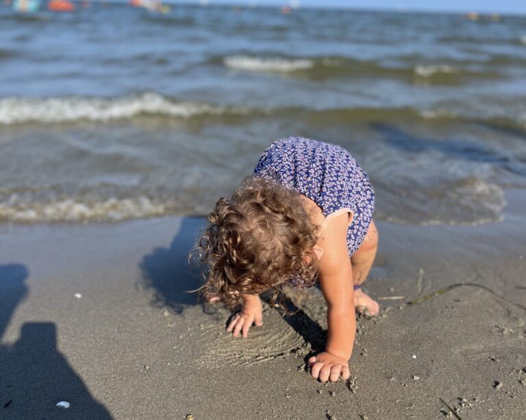 Bambina piccola in riva al mare per la prima volta