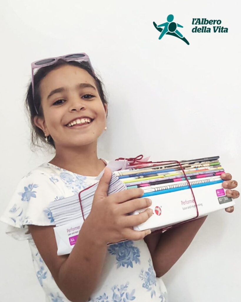 Bambina sorridente con quaderni e materiale scolastico